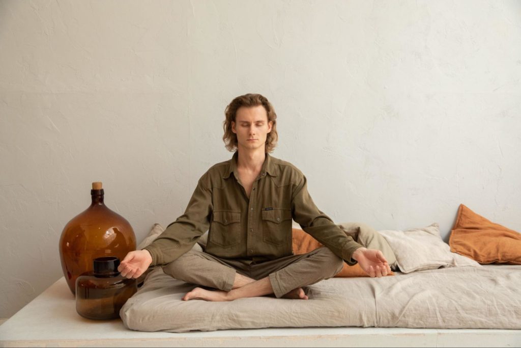 A man doing meditation on bed